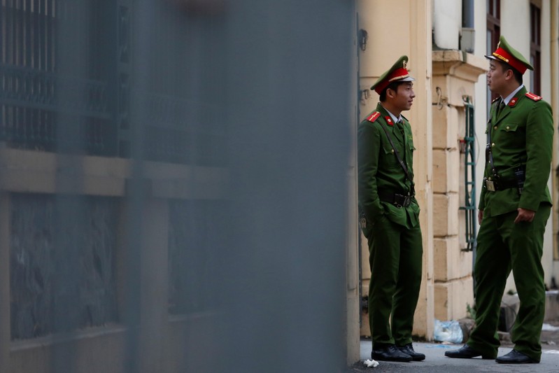 Vietnamese policemen stand guard outside the court in Hanoi