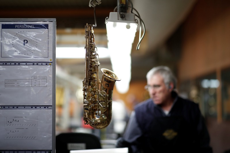 A part of a saxophone hangs at the Henri Selmer wind instruments factory in Mantes-la-Ville near Paris