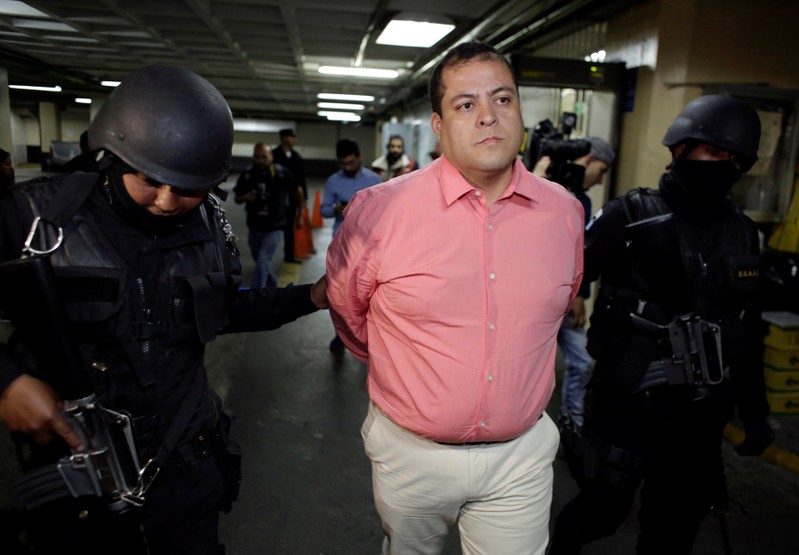 Congressman Julio Juarez Ramirez, who is accused of plotting the murders of two journalists in 2015, is escorted by police officers while arriving to the court in Guatemala City
