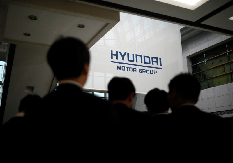 Employees of Hyundai Motor walk past the company's logo after the company's New Year ceremony in Seoul