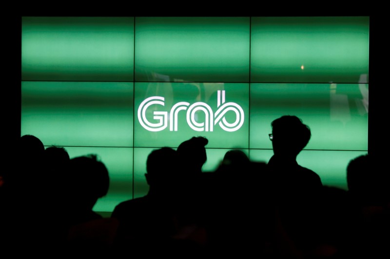 FILE PHOTO - People wait for the start of Grab's fifth anniversary news conference in Singapore