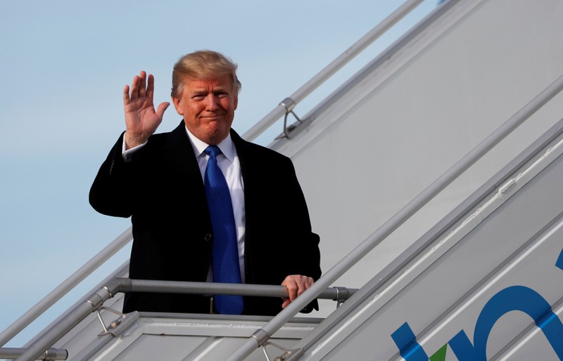 U.S. President Donald Trump waves as he arrives in Zurich