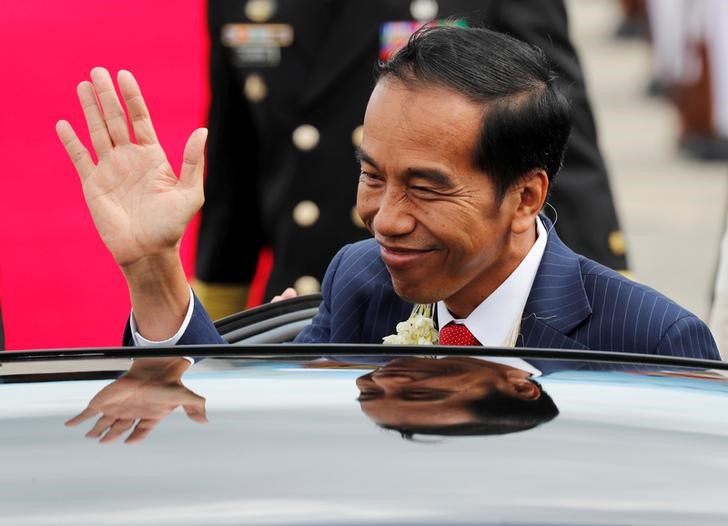 Indonesian President Joko Widodo waves to the student performers upon his arrival to attend the ASEAN Summit and related meetings in Clark, Pampanga