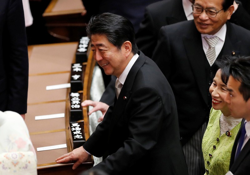 Prime Minister Shinzo Abe talks with other lawmakers after attending the opening of a session of parliament in Tokyo
