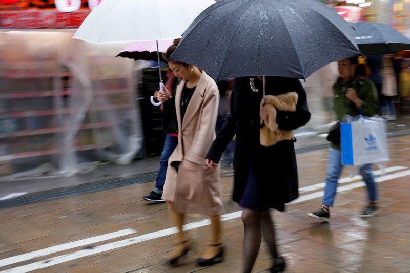 FILE PHOTO: Shoppers walk through the rain in an Osaka shopping district
