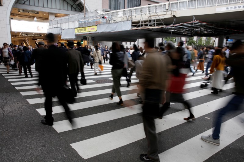 FILE PHOTO: Commuters cross a pedestrian crossing in Osaka