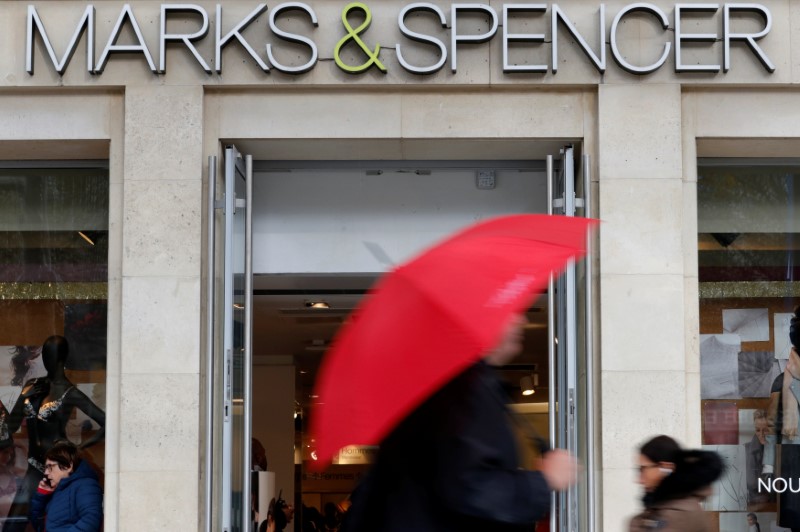 FILE PHOTO: Pedestrians walk past a Marks & Spencer store on the Champs Elysees avenue in Paris