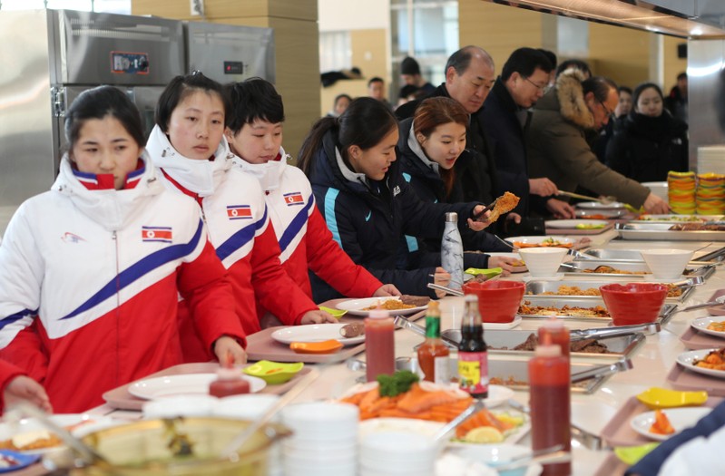 North and South Korea women's ice hockey athletes stand in a line at a dining hall at the Jincheon National Training Centre in Jincheon