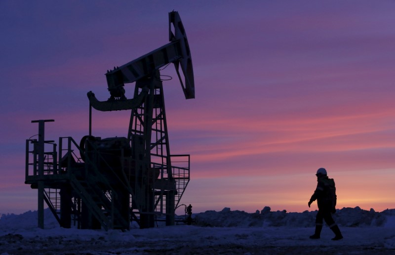 FILE PHOTO: A worker walks past a pump jack on an oil field owned by Bashneft in Bashkortostan
