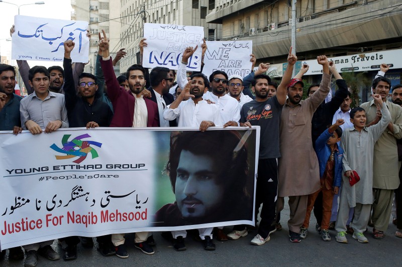 People chant slogans and hold signs as they condemn the death of Naqibullah Mehsud, during a protest in Karachi,