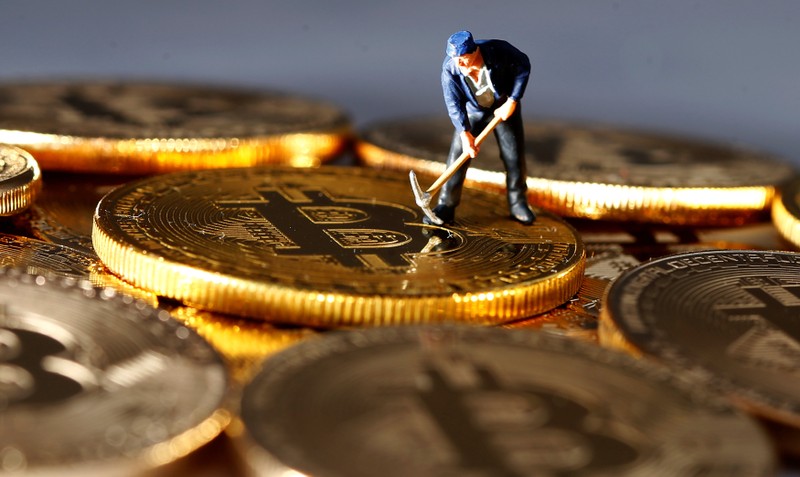 A small toy figure is seen on representations of the Bitcoin virtual currency in this illustration picture