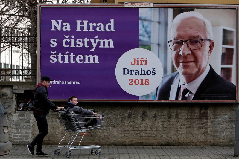 People pass a poster of presidential candidate Jiri Drahos in Prague