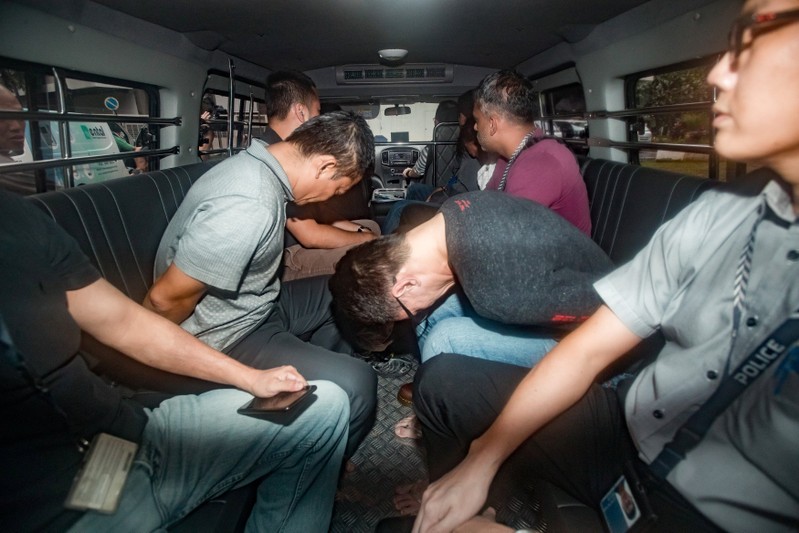 Suspects arrive in a van at the State Courts in Singapore