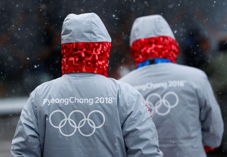 Volunteers for the upcoming 2018 Pyeongchang Winter Olympic Games walk in Pyeongchang