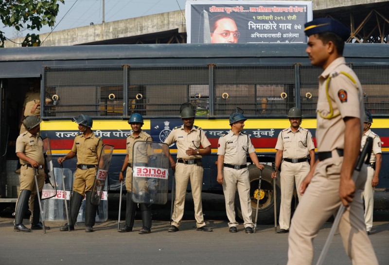 Policemen stand guard at a traffic junction in Mumbai