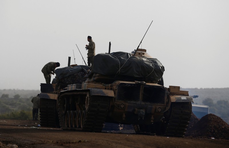 Turkish soldiers stand on tanks in a village on the Turkish-Syrian border in Gaziantep province