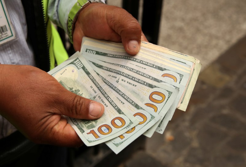 FILE PHOTO: A money changer holds U.S. dollar bills at a street in downtown Lima