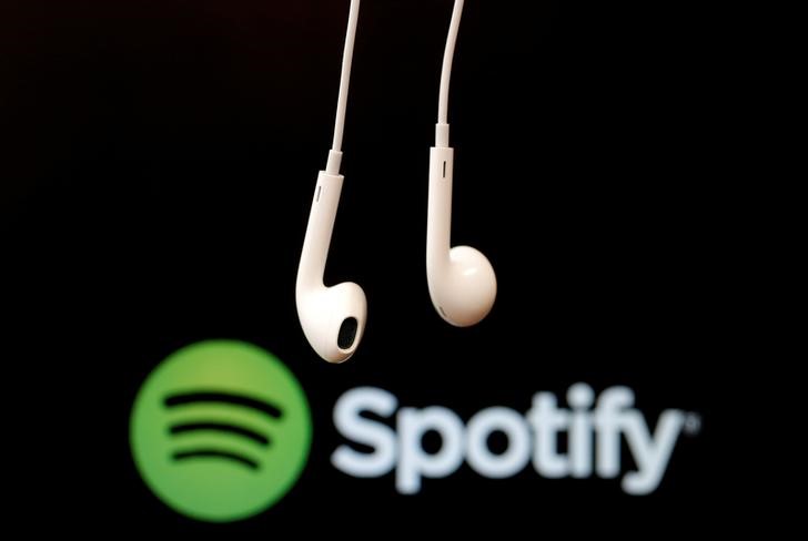 Headphones are seen in front of a logo of online music streaming service Spotify in this illustration picture