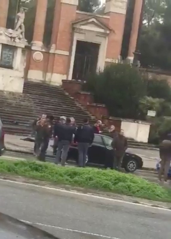 People gather where witnesses say a shooter was arrested in Macerata