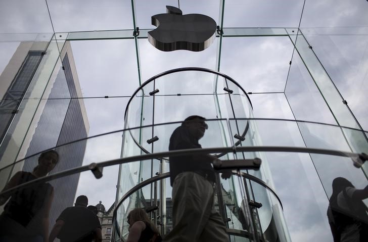 Customers enter the Apple store on 5th Avenue beneath an Apple logo in the Manhattan borough of New York City