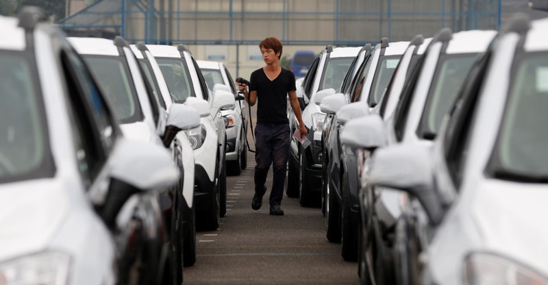 FILE PHOTO: A worker checks cars made by GM Korea in a yard of GM Korea's Bupyeong plant in Incheon