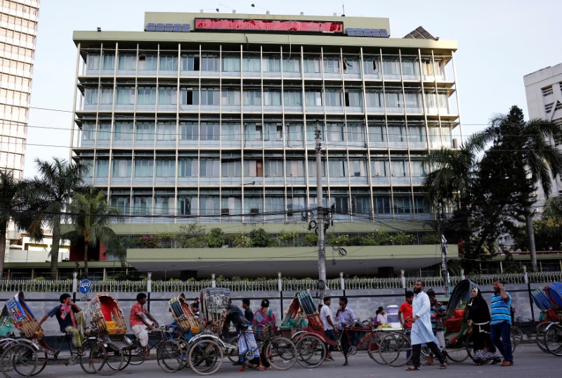 Commuters walk in front of the Bangladesh central bank building in Dhaka