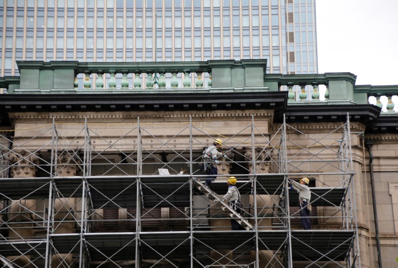Workers are seen on scaffolds on the Bank of Japan building that is undergoing construction works in Tokyo, Japan