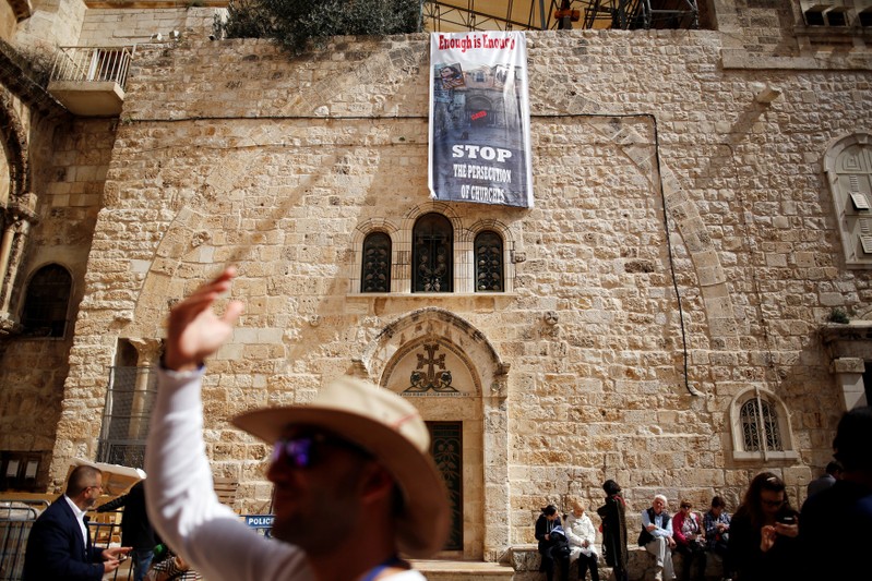 A banner hangs from a wall next to the entrance of the Church of the Holy Sepulchre, in Jerusalem's Old City