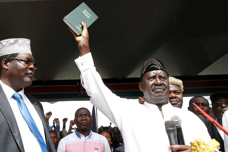 Kenyan opposition leader Raila Odinga of the National Super Alliance (NASA) holds a bible as he takes a symbolic presidential oath of office in Nairobi, Kenya