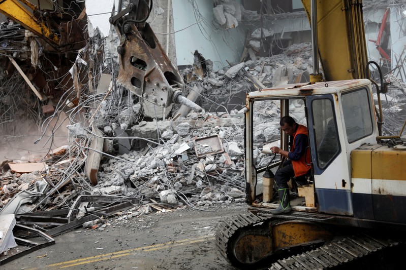 An excavator demolishes collapsed Marshal hotel after an earthquake hit Hualien