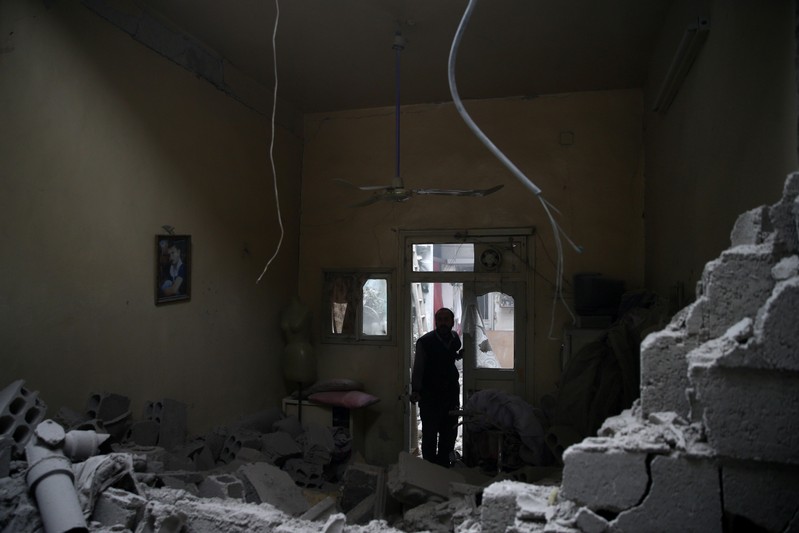 FILE PHOTO: A man inspects a damaged house in the besieged town of Douma
