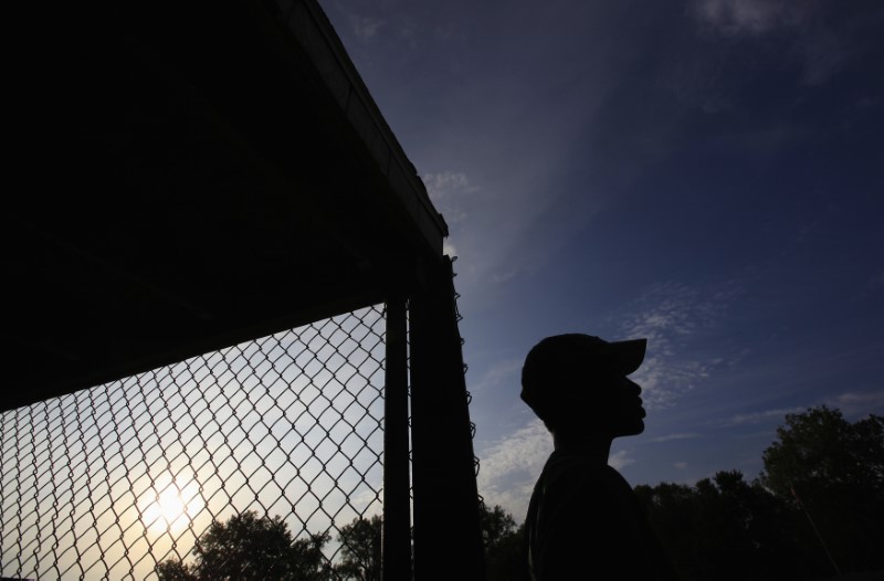 A boy watches his team play in a little league game in Beardstown