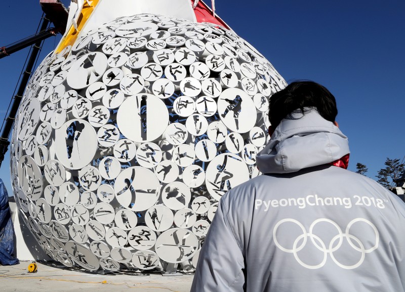 FILE PHOTO: A volunteer stands at the base of the Olympic Cauldron for the upcoming 2018 Pyeongchang Winter Olympic Games at the Alpensia resort in Pyeongchang