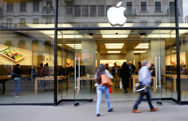 FILE PHOTO: People walk in front of a branch of U.S. technology company Apple in Zurich