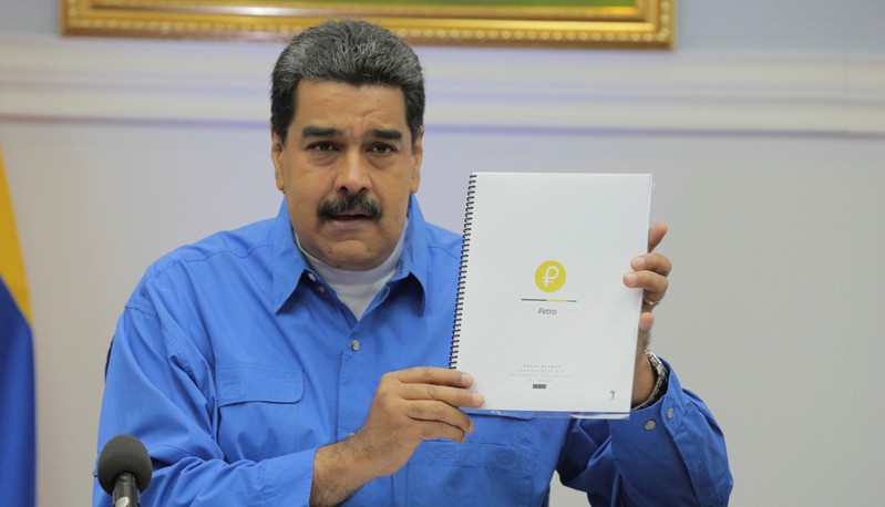 Venezuela's President Nicolas Maduro holds a document as he speaks during a meeting with ministers in Caracas