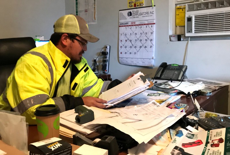 Ortega, a supervisor at an infrastructure safety company, reviews budget paperwork in San Antonio