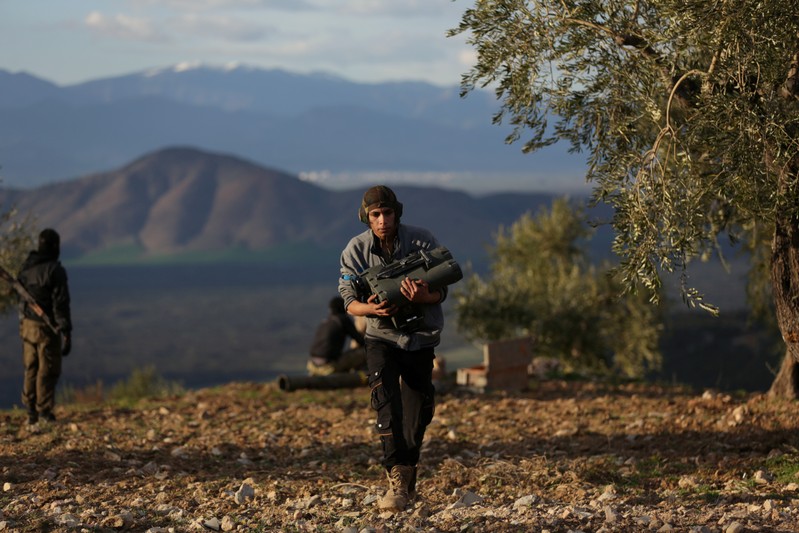 A Turkish-backed Free Syrian Army fighter carries a military binoculars north of the city of Afrin