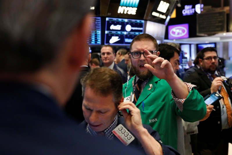 FILE PHOTO: Traders work on the floor of the New York Stock Exchange shortly after the opening bell in New York