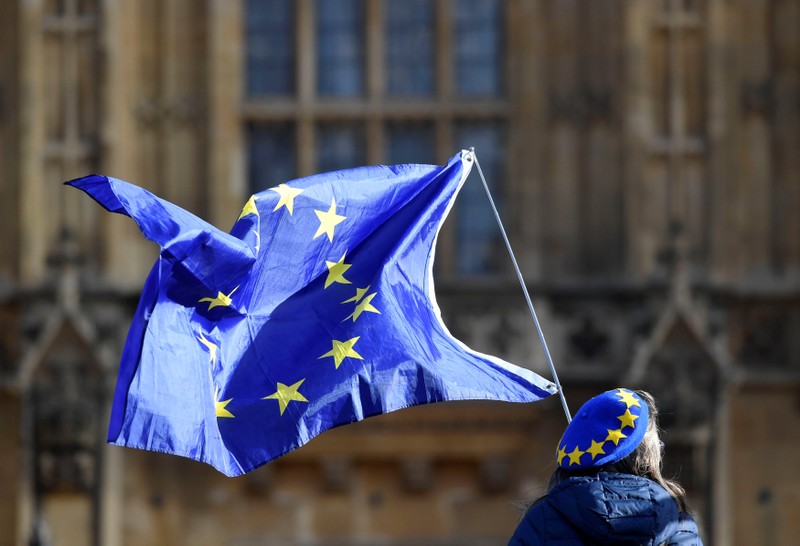 An anti-Brexit demonstrator waves a EU flag outside the Houses of Parliament in London