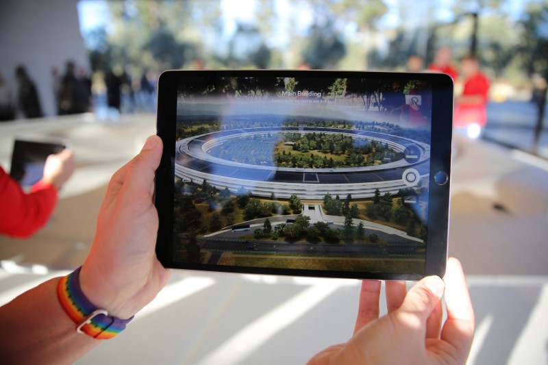 An Apple employee uses an iPad with an augmented reality app on it to show off features of the new Apple Park at the Apple Visitor Center in Cupertino