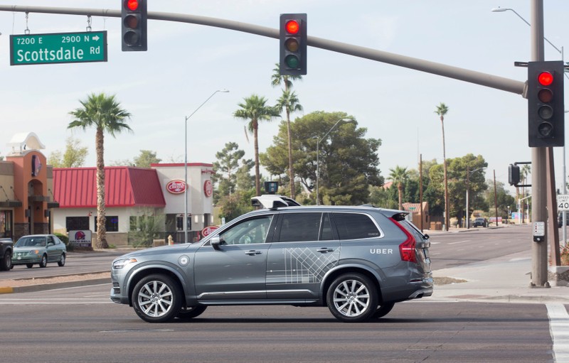 FILE PHOTO: A self driving Volvo vehicle, purchased by Uber, moves through an intersection in Scottsdale