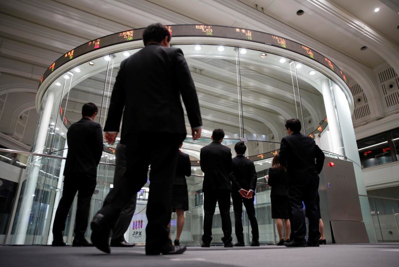 Visitors look at the TSE bourse in Tokyo