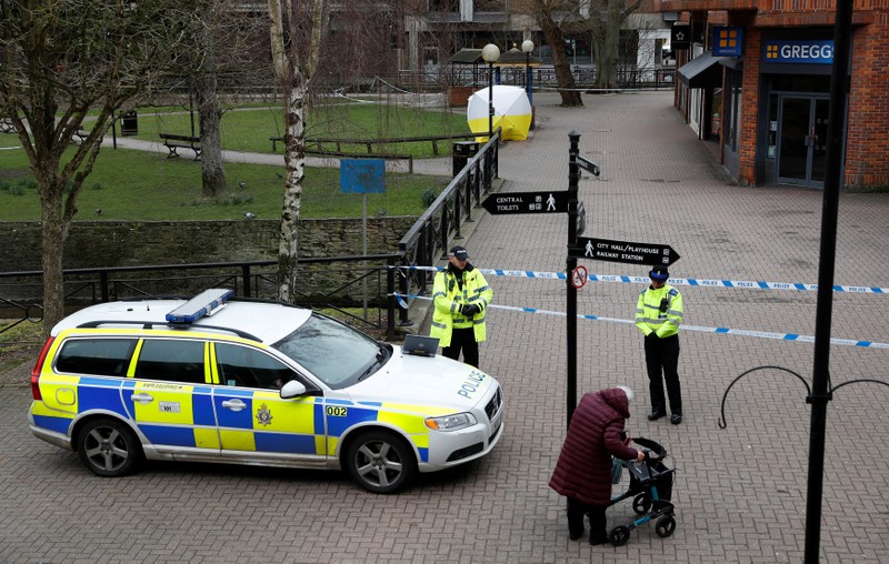 Police officers continue to guard the scene where a forensic tent, covering the bench where Sergei Skripal and his daughter Yulia were found, has been erected in the centre of Salisbury
