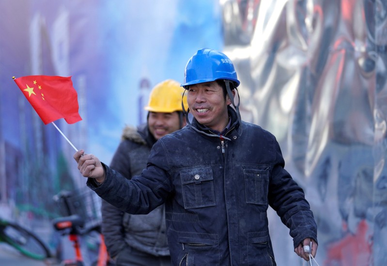 Labourers walk outside a construction site in Beijing's central business area