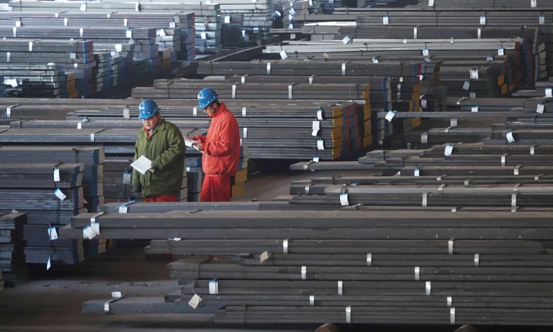 FILE PHOTO: Workers check steel bars at a factory of Dongbei Special Steel Group Co., Ltd. in Dalian