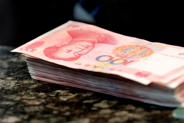 FILE PHOTO - Chinese 100 yuan banknotes are seen on a counter of a branch of a commercial bank in Beijing