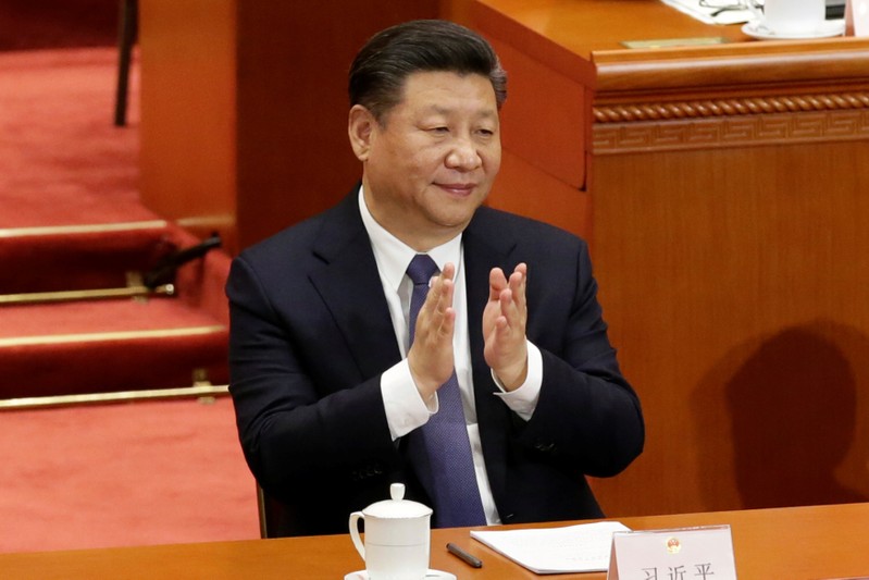 Chinese President Xi Jinping applauds at the third plenary session of the National People's Congress (NPC) at the Great Hall of the People in Beijing