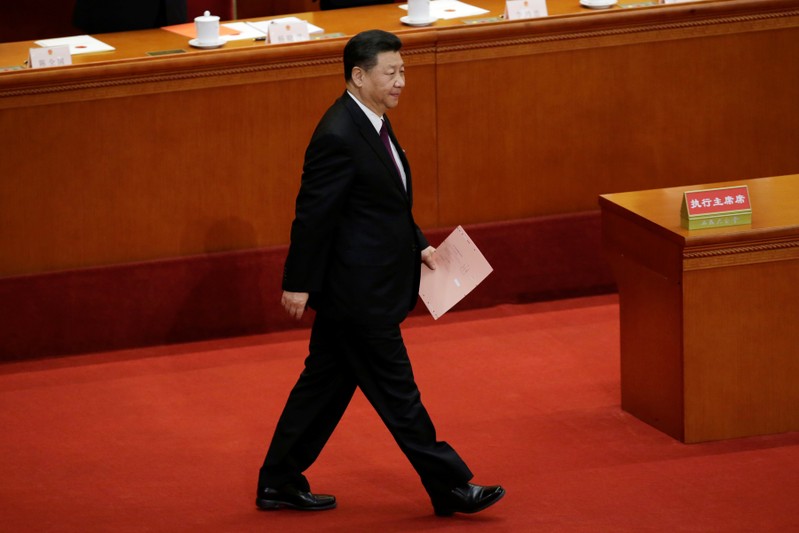 Chinese President Xi Jinping walks with his ballot before a vote at the fifth plenary session of the National People's Congress (NPC) at the Great Hall of the People in Beijing