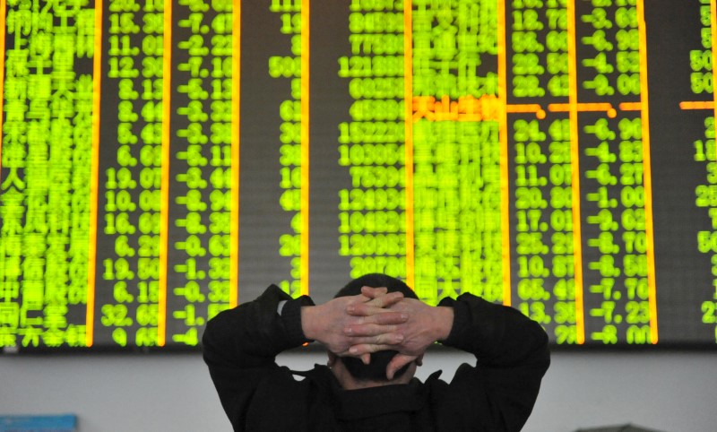 FILE PHOTO: An investor looks at an electronic screen at a brokerage house in Hangzhou