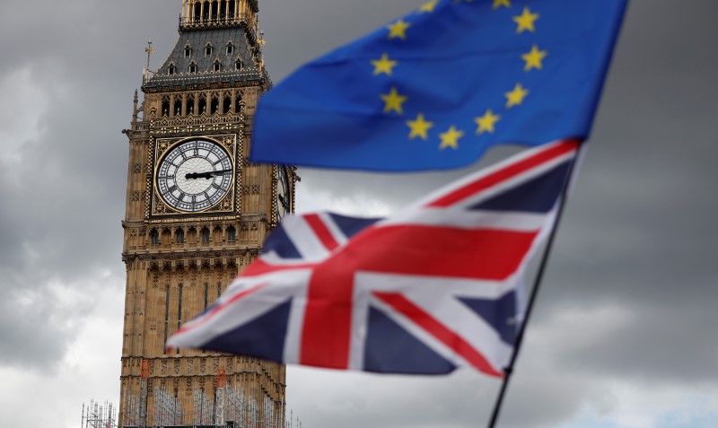 The Union Flag and a European Union flag fly near the Elizabeth Tower, housing the Big Ben bell, during the anti-Brexit 'People's March for Europe', in Parliament Square in central London